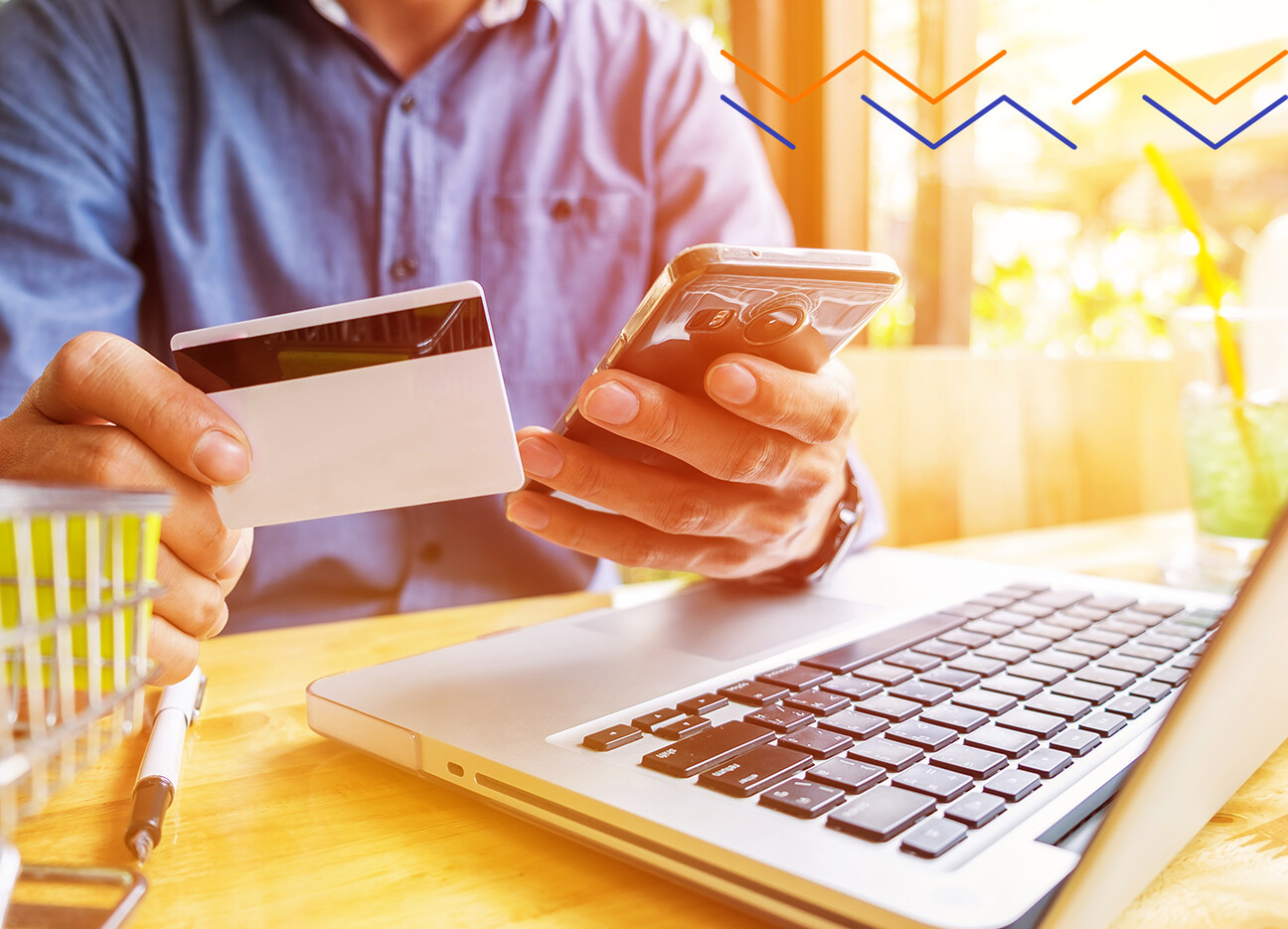 Amazon Predictions 2021 | Person holding a credit card and phone while sitting in front of a computer